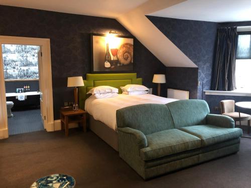 a bedroom with a bed and a couch and a chair at One Devonshire Gardens a Hotel Du Vin in Glasgow