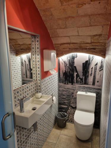 a bathroom with a white toilet and a sink at Hostal La Rúa in Estella