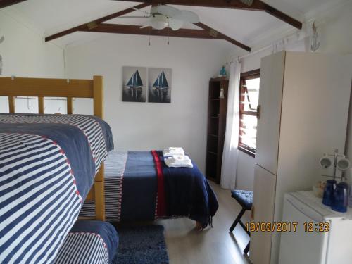 1 dormitorio con 2 camas y ventilador de techo en Lala Phantsi en Chintsa