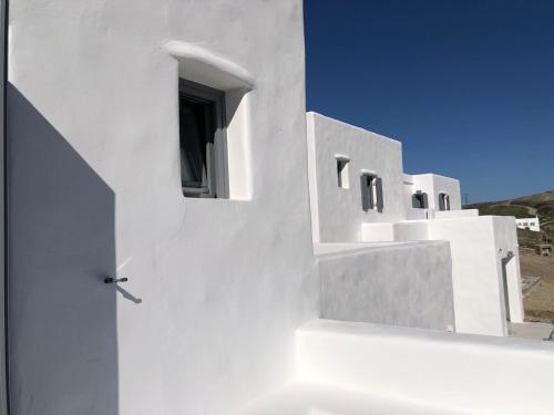 a white building with a door and a window at Krotiri View Paros in Krotiri