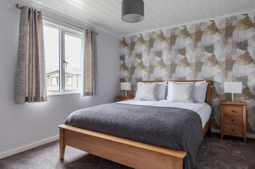 a bedroom with a large bed and a window at Roydon Marina Village Lodges in Roydon