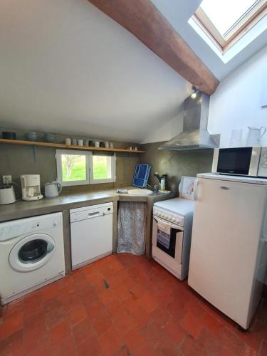 une cuisine avec un réfrigérateur blanc et un évier dans l'établissement Gîte