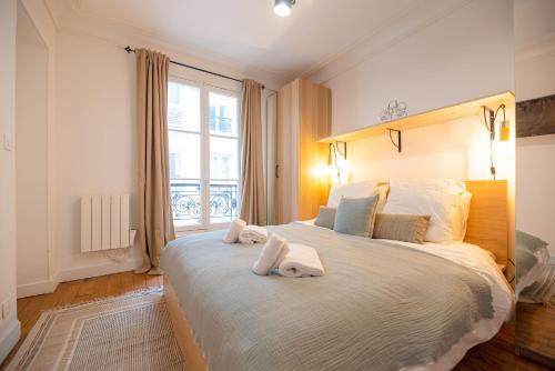 a bedroom with a large bed with towels on it at Luxury flat Victor Hugo in Paris