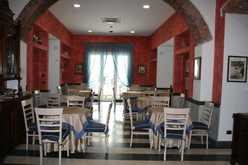 ein Esszimmer mit Tischen, Stühlen und einem Fenster in der Unterkunft Hotel La Spiaggia in Monterosso al Mare