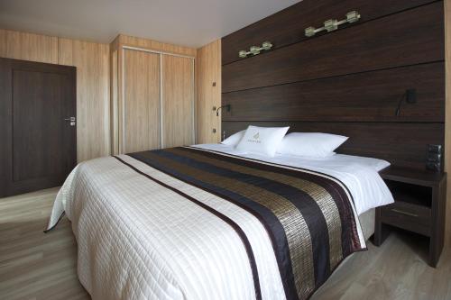 a bedroom with a large bed with a wooden headboard at Aparton in Ustka