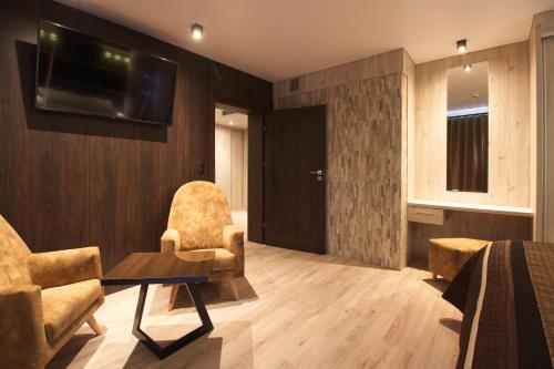 a room with two chairs and a tv on a wall at Aparton in Ustka