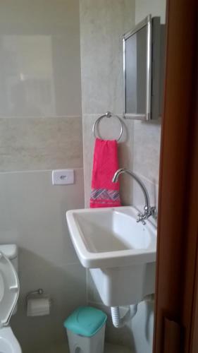a bathroom with a white sink and a pink towel at Kitnet 1,Vista fantastica in Cabo de Santo Agostinho