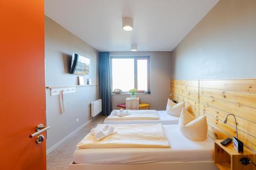 a hotel room with three beds in it at Haus 54 in Zingst