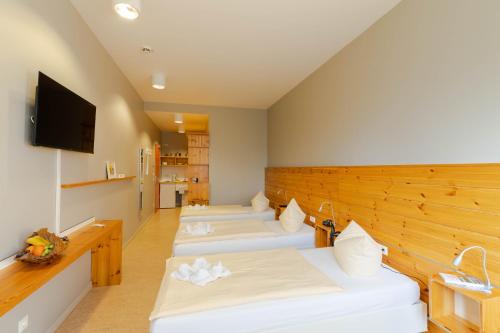 a room with four beds and a flat screen tv at Haus 54 in Zingst