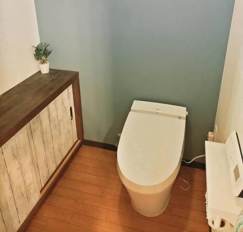 a bathroom with a toilet and a wooden cabinet at Gerobal Hostel in Gero