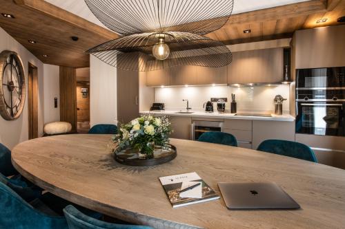 a kitchen with a table with a laptop on it at Manali Lodge by Alpine Resorts in Courchevel