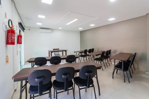 a classroom with tables and chairs in a room at Hotel Werlich in São José