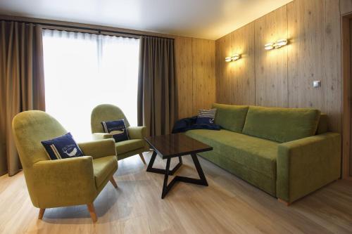 a living room with a couch and two chairs and a table at Aparton in Ustka