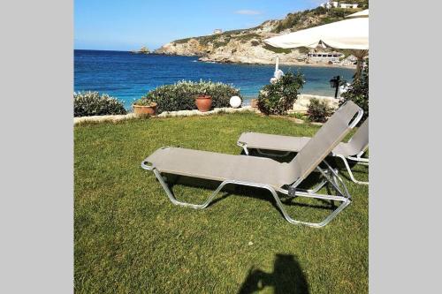 a beach chair sitting on the grass next to the ocean at Dreamwave Residence - Unique holidays by the sea in Lygaria