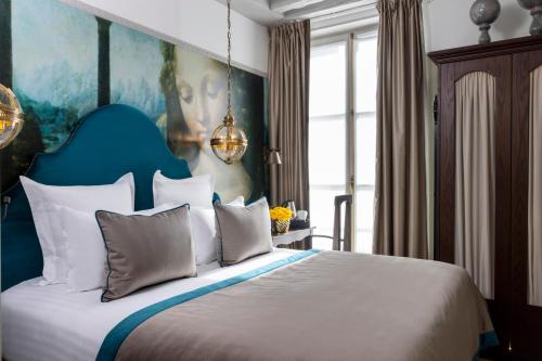 a bedroom with a large bed with a painting on the wall at Hôtel Vinci Due & Spa in Paris
