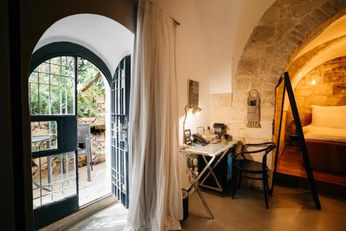 a room with a bed and a desk and a window at Alegra Boutique Hotel in Jerusalem