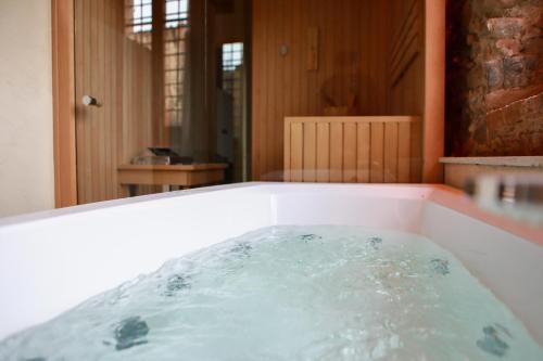 a bath tub filled with water in a room at Corte Regia Relais & Spa in Valeggio sul Mincio