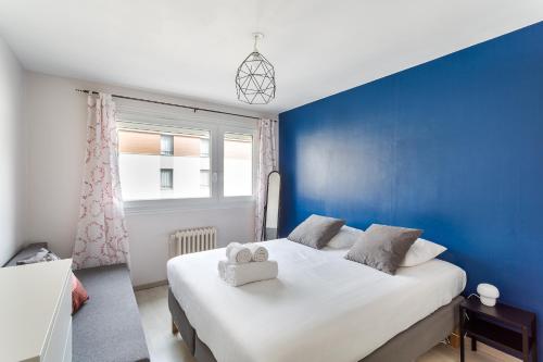 a blue bedroom with a white bed and a window at LORGERIL -appartement 2 chambres proche Mail in Rennes