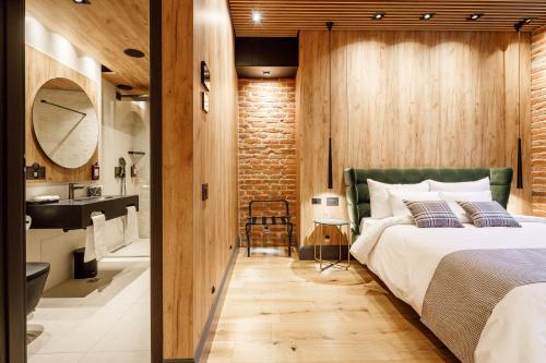 a bedroom with a large bed and a bathroom at SCHUSTER Boarding House in Braşov