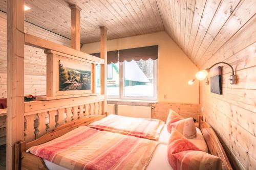 a bedroom with a bed and a window at Ferienhotel Goldhübel in Neuhausen