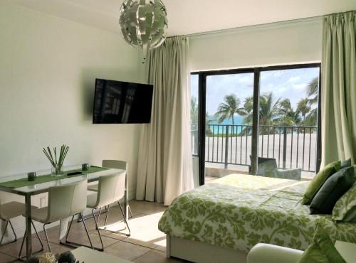 1 dormitorio con cama, escritorio y balcón en Miami Beach Suncoast Apartment I - Balcony Front Beach, en Miami Beach