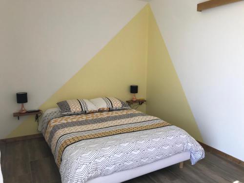 a bedroom with a bed with a pointed ceiling at les costebelles in Valensole