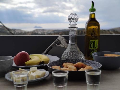 a table with food and a bottle of wine and glasses at House of Sunset - Tranquility - View - Relaxation in Sívas