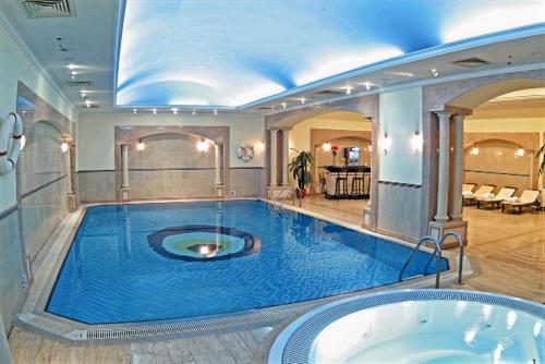 a large swimming pool in a room with a tub at Occidental Taksim in Istanbul