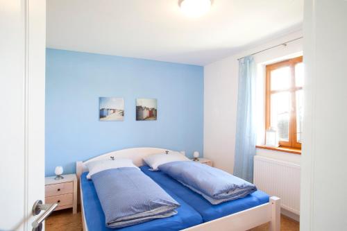 a blue bedroom with a bed with blue walls at Das Landhaus in Mainleus