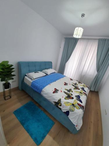 Schlafzimmer mit einem Bett mit blauem Kopfteil in der Unterkunft Apartament 3 camere militari residence in Roşu