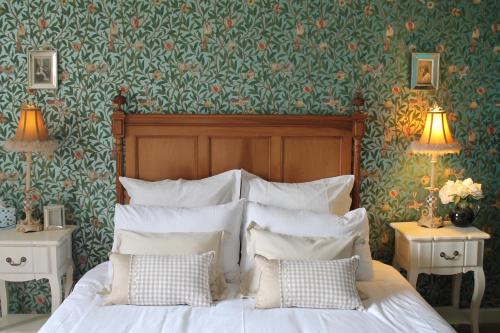 a bed with white pillows in a bedroom with floral wallpaper at stay bed and breakfast in Culross