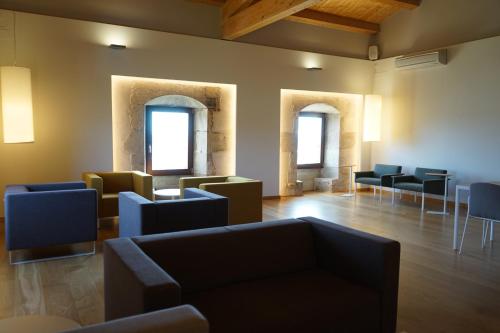 una sala de espera con sofás, mesas y ventanas en Hotel Santuari, en Balaguer