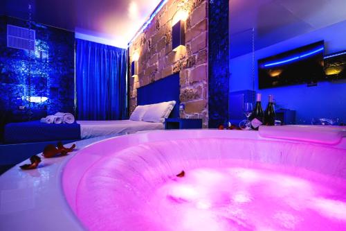 a large pink tub in a room with a bed at Villa Asfodelo Guest House & Relax in Alghero