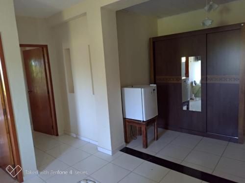 a room with a refrigerator and a wooden door at HOTEL PRAIA DA PAIXÃO in Prado