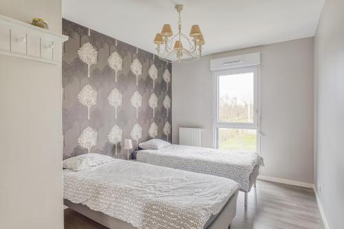 ein Schlafzimmer mit zwei Betten und einem Fenster in der Unterkunft Ker Eno in Dinard