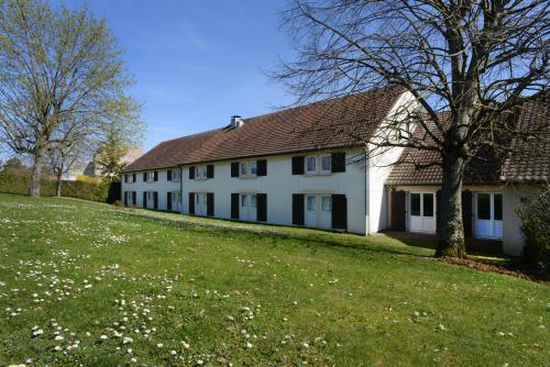 una gran casa blanca con césped y árboles en Hotel inn Dijon-Quetigny, en Quetigny