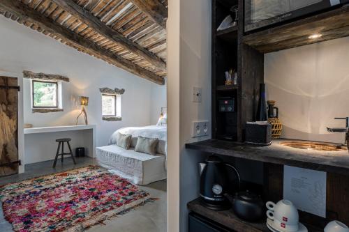 a bedroom with a bed and a bathroom with a sink at Le Domaine du Castellas in Sivergues