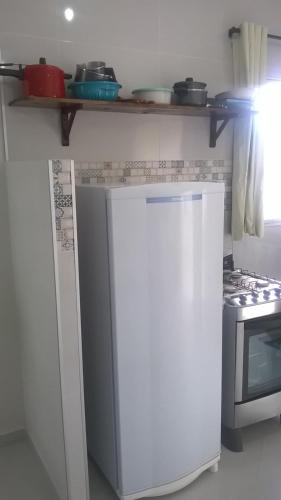 a kitchen with a white refrigerator and a stove at Cobertura com área privativa,a melhor Vista. in Cabo de Santo Agostinho