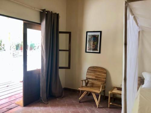 a bedroom with a bed and a chair and a window at Gîte du Lac in Niaga