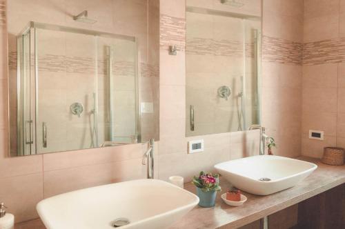 ein Badezimmer mit zwei Waschbecken und einem großen Spiegel in der Unterkunft PURA B&b in Noicattaro