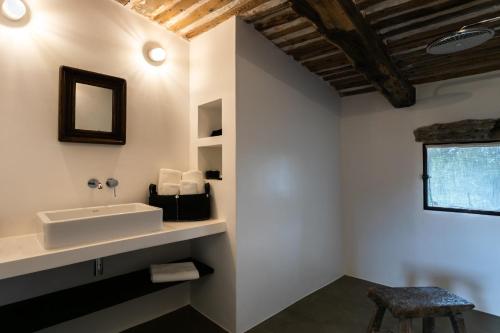 a bathroom with a sink and a stool at Le Domaine du Castellas in Sivergues