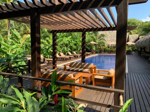 una piscina en un complejo con tumbonas y pérgola en Casa Bambu Tayrona, Los Naranjos en Los Naranjos