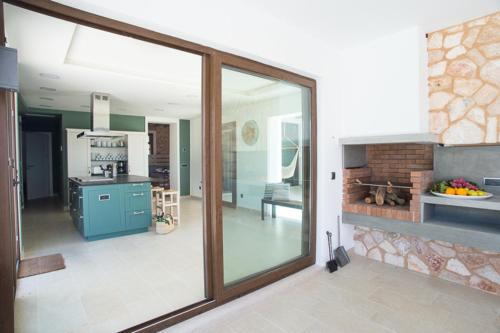a living room with a large glass window and a kitchen at Villa Ferrer de SHorta in S'Horta