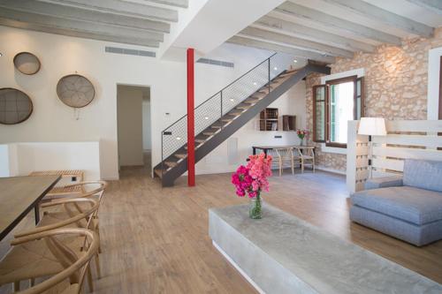 a living room with a staircase and a vase of flowers at Villa Ferrer de SHorta in S'Horta