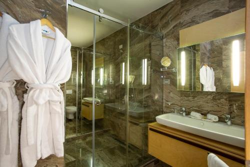 a bathroom with a sink and a shower at Best Western Premier Ark Hotel in Tirana