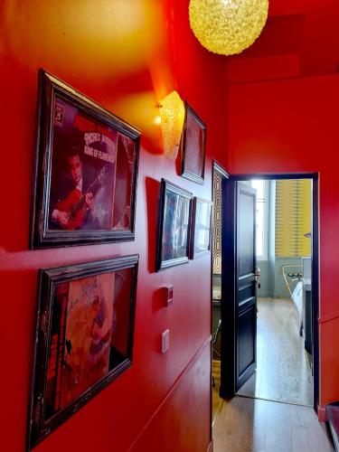 a hallway with a red wall with pictures on it at B&B Casa Ortega in Marseille