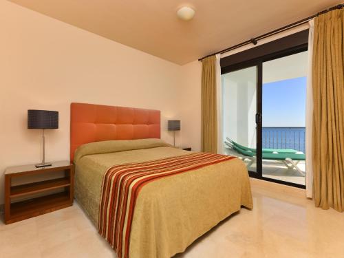 a bedroom with a bed and a large window at Precioso apartamento de 2 dormitorios con parking & WiFi in Torrox Costa