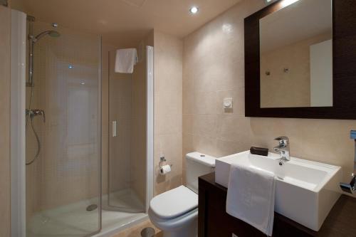 e bagno con servizi igienici, lavandino e doccia. di Spacious 3 bedrooms apartment side sea view a Torrox Costa
