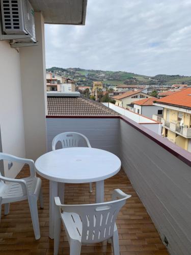uma mesa branca e cadeiras numa varanda em Appartamento al Mare em Martinsicuro
