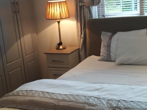 a bedroom with a bed with a lamp on a night stand at Westhouse Cafe in Longford